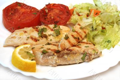 Grilled white fish and tomato with fresh salad on plate. Isolate