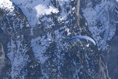Hovering paraglider in the mountains