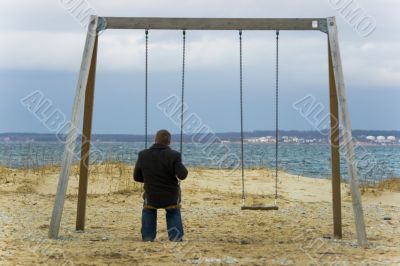 Man alone on swings