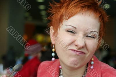 red haired woman is smiling in cafe