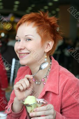 woman eating ice cream in cafe and smiling happy