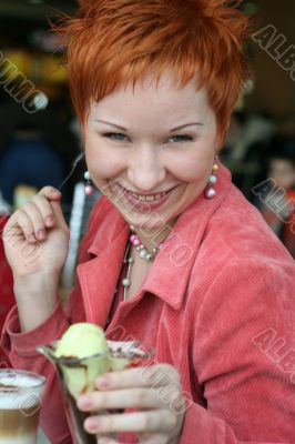 woman eating ice cream in cafe and smiling happy