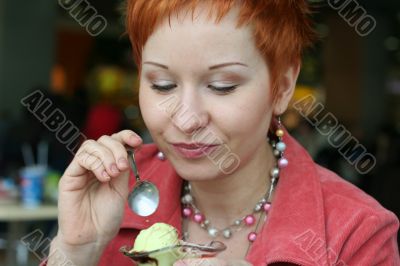 woman eating ice cream in cafe and smiling happy