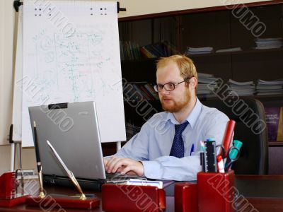 Man in his office is working at laptop