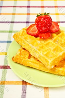 Waffles and strawberries on green plate
