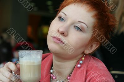 woman dreanking coffe in cafe and thoughtfully looks afar