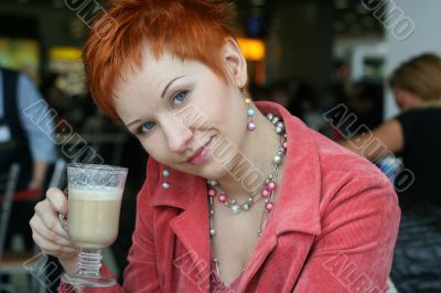 woman dreanking coffe in cafe and thoughtfully looks afar