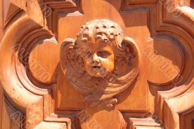 Carved wooden angel face on chapel door