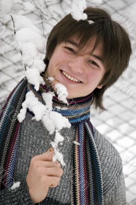 Pretty  European teens boy with snown branch