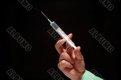an’s hand holding syringe
