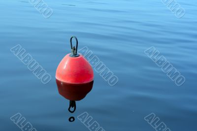 red-orange buoy in the blue water