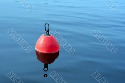 red-orange buoy in the blue water