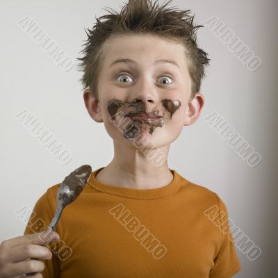 Boy`s face dirty with chocolate