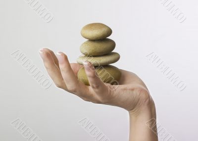 Hand holding 4 zen stones