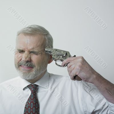 Man poiting gun at his head