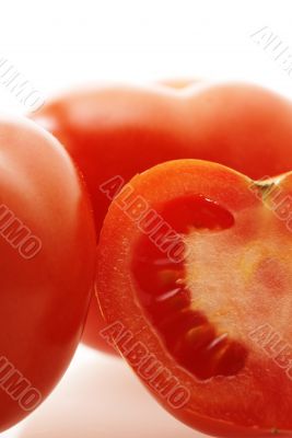 close up shot of ripe juicy tomatoes over white