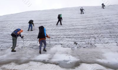 Six people trekking on a glacier.