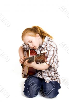 little girl playing on a guitar