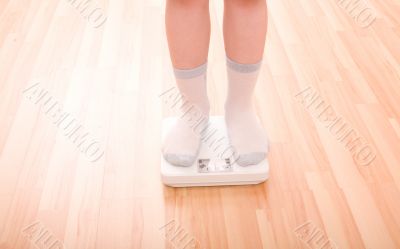 Boy measures weight on floor scales