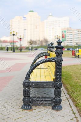 Park bench with city skyline behind