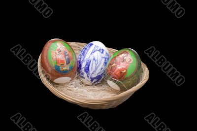 Easter eggs in a basket on the isolated black background