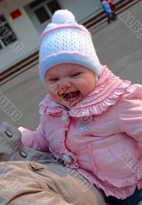 Pretty little girl on mother`s hands.