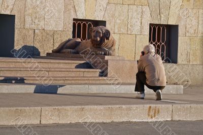 Hiker take a photograph granite sculpture lion