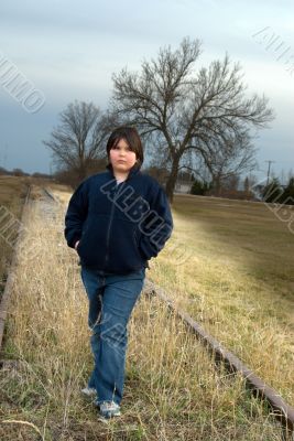 Girl Standing on Railroad Tracks
