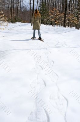 Woman walking in snow shoes in the forest
