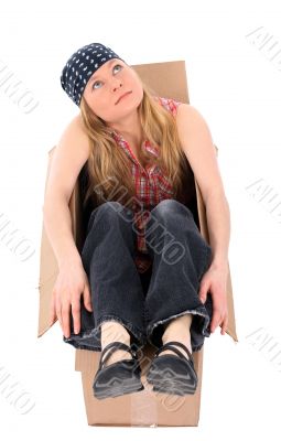 Girl sitting in a cardboard box, looking up