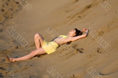 blond girl lying on the beach