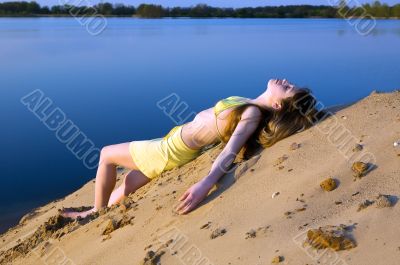 blond girl lying on the beach