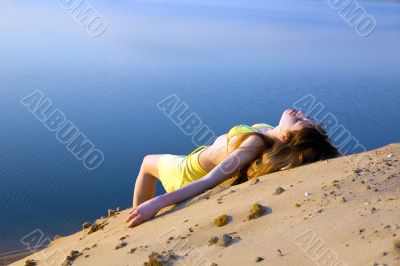 blond girl lying on the beach