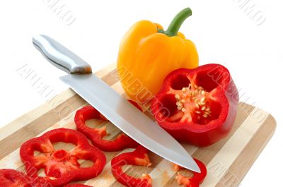 Red and yellow paprika on bamboo cutting board.