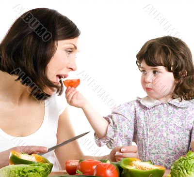 mother and daughter cooking at the kitchen