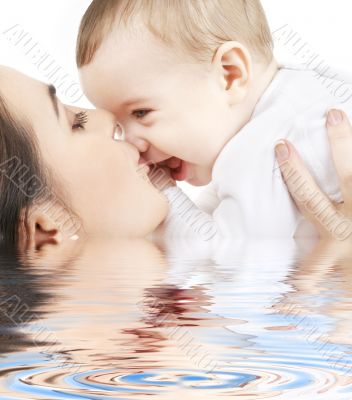 happy mother kissing baby boy in water