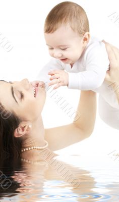 happy mother with baby boy in water
