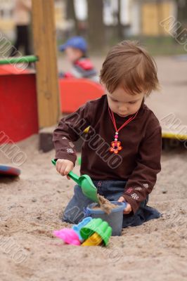 little girl playing at sand-box