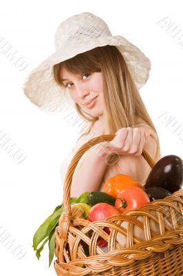 An attractive young woman holding a basket of delicious fresh vegetables. Isolated on white.