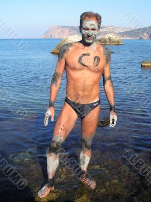 Man, smeared by therapeutic mud at sea