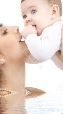 happy mother playing with baby boy in water