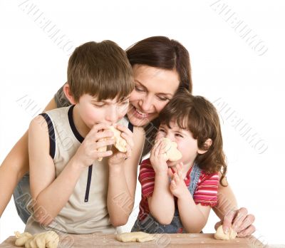 mother and children in the kitchen making a dough