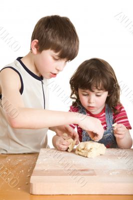 children in the kitchen making a dough