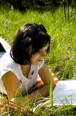 pretty young brunette readind in the park