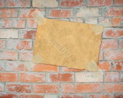 Sheet paper, hanging on a brick wall