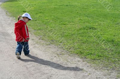 little girl and her shadow in the road of spring park