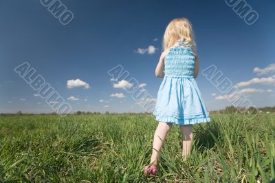 little girl on wide green meadow