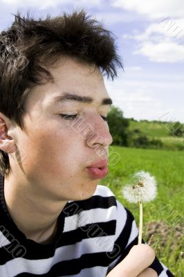 Teenager blowing dandelion