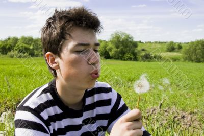 Teenager blowing dandelion