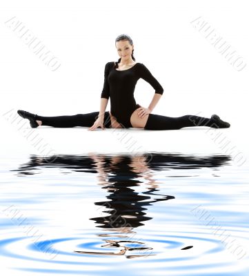 fitness instructor in black leotard on white sand